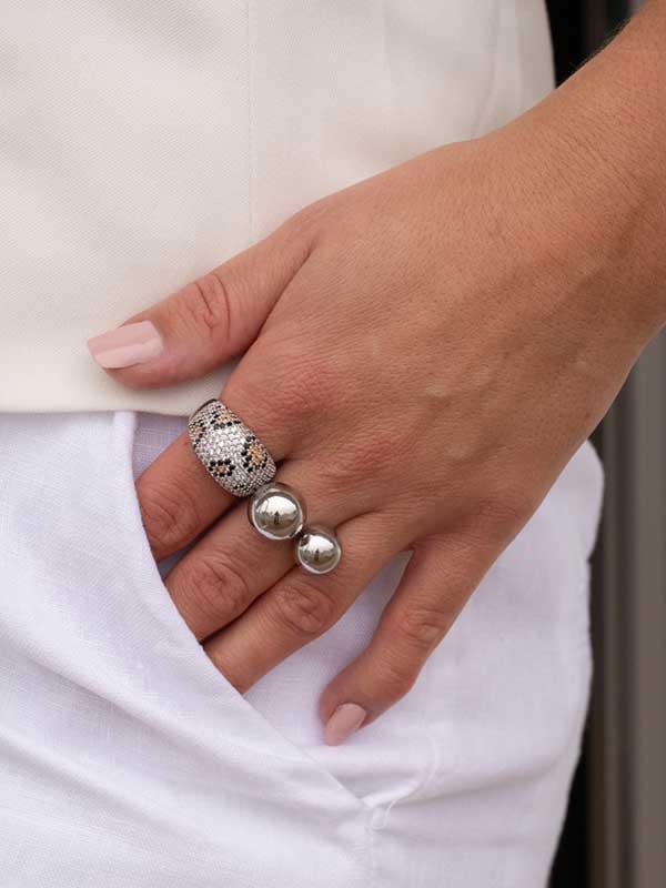 Lyxig silverring med stenar som bildar ett leopardmönster.