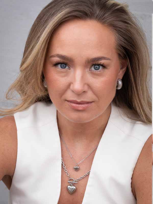 Ett par silverhoops örhängen med mönstrad yta.