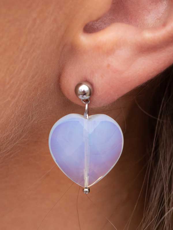 Ett hjärtörhänge i glas med en kultopp.