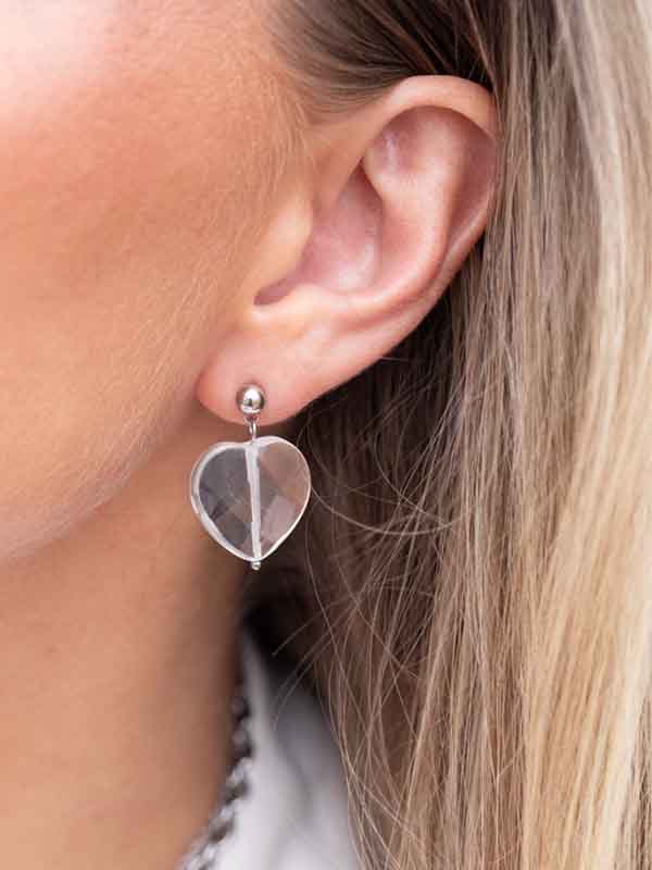 Ett hjärtörhänge i glas och rostfritt stål.